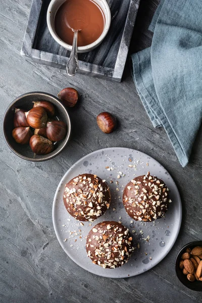 Sweet chestnut cups filled with soft curd cheese, chestnut puree and ground almonds, topped with chocolate frosting and chopped nuts