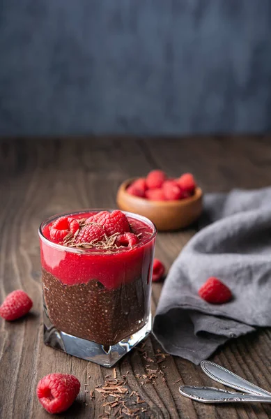 Superfood healthy vegan dessert, dark cocoa chia seed pudding with raspberry puree, topped with fresh berries and chocolate shavings in a glass jar — Stock Photo, Image