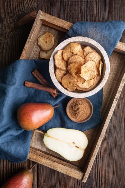 Sött läckert mellanmål, hemlagad ugn torkad krispiga päron chips strös med kanel — Stockfoto