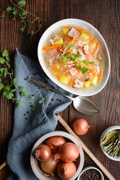Капушняк, классический польский суп из квашеной капусты, свиные ребрышки, копченый бекон, картофель, морковь и другие овощи — стоковое фото