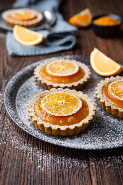Plně pšeničné kurkumové koláčky plněné meruňkovou marmeládou, zdobené sušenými pomeranči, zakončené práškovým cukrem — Stock fotografie