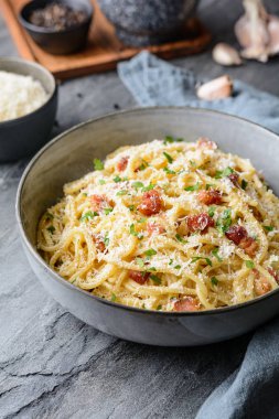 Klasik Carbonara makarnası, spagetti, yumurta, kızarmış pastırma rendelenmiş parmesan peyniri ve karabiberli İtalyan yemeği.
