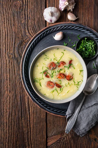 Caldo Verde soup made of savoy cabbage, pureed potatoes, onion, garlic and fried sausage slices in a ceramic bowl — Stock Image Caldo Verde soup made of savoy cabbage, pureed potatoes, onion, garlic and fried sausage slices in a ceramic bowl Stock Image