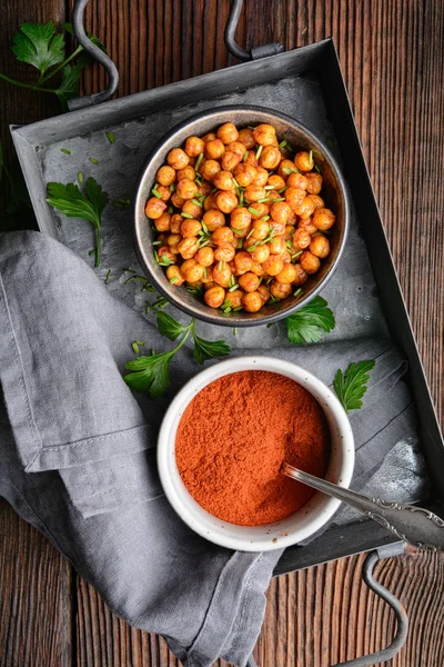 Krusande mellanmål, krispiga och kryddiga ugnsrostade kikärter täckta med paprika och rött chilipulver — Stockfoto