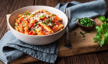 Classic penne all'Arrabbiata, spicy pasta with tomato and chilli sauce, topped with grated cheese