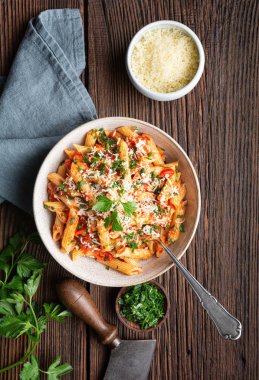 Classic penne all'Arrabbiata, spicy pasta with tomato and chilli sauce, topped with grated cheese