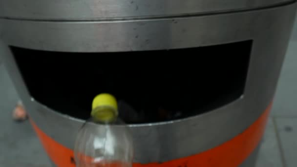 Mann wirft leere Recycling-Plastikflasche in Mülleimer. — Stockvideo