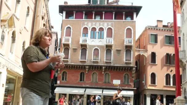 Retrato de una mujer caucásica mayor comiendo sándwich al aire libre. Italia — Vídeos de Stock