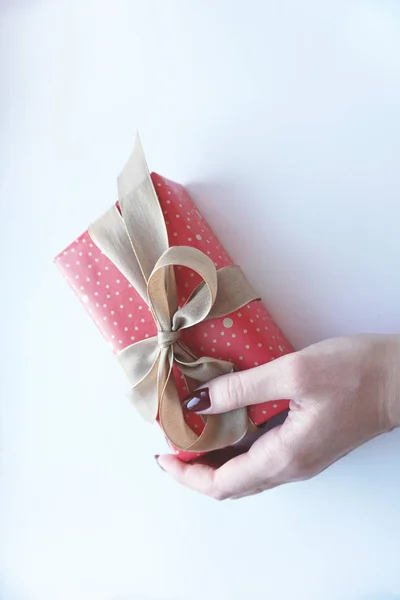 Frauen Hand hält Geschenkbox auf weißem Hintergrund. — Stockfoto