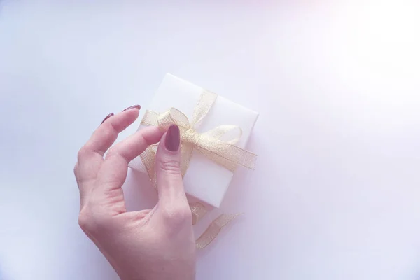 Present gift box with gold bow on white background. — Stock Photo, Image