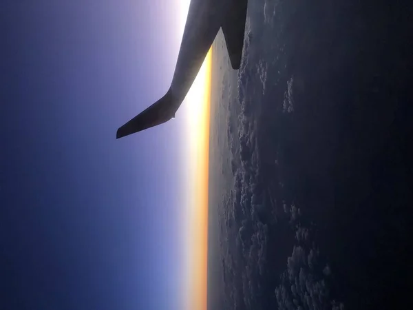 Nuvens e céu através da janela de um avião . — Fotografia de Stock