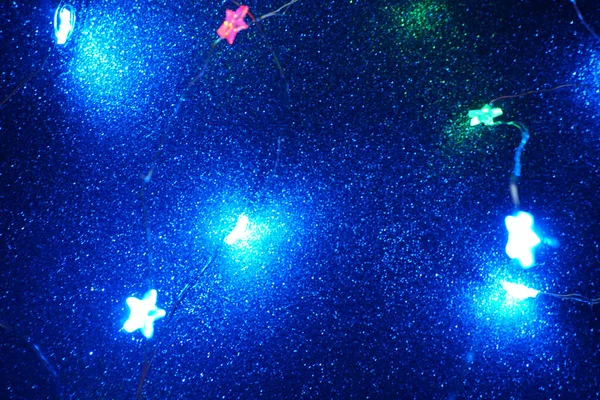 Guirnalda colorida de Navidad desenfocada con estrellas . — Foto de Stock