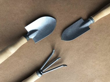 Kahverengi arkaplanda düzenlenmiş bahçe araçları.