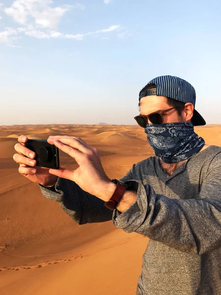 Homme prenant des photos au smartphone dans le désert. Concept de voyage . Image En Vente