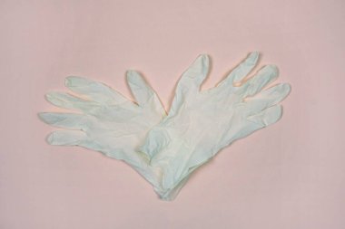 Pembe arka planda tıbbi eldivenler