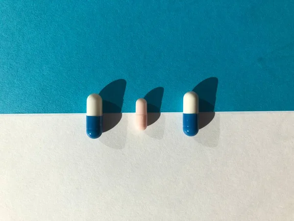 Mavi arka planda mavi ve beyaz haplar.