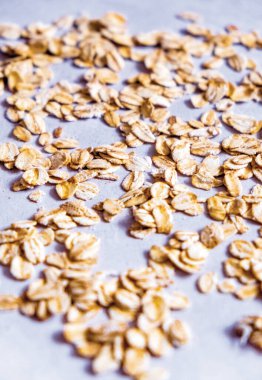 Gri bir yüzeye yayılmış yuvarlak yulafın dikey görüntüsü. Yulaf, yüksek beslenme lifleri, B vitaminleri ve Demir.