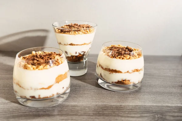 Klasik tiramisu tatlısı. Gri ahşap arka planda bir bardak içinde..