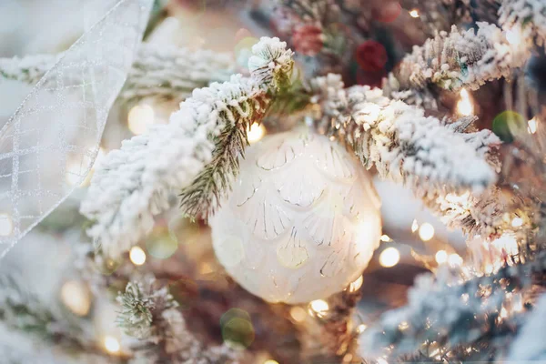 Karlı bir dalda topları ve ışıkları olan yeni yıl kartı..