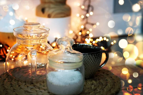 Mutfakta ışıklar ve bokeh ile Noel toplantısı. Hasır tezgahın üzerinde şeker dolu bir fincan..