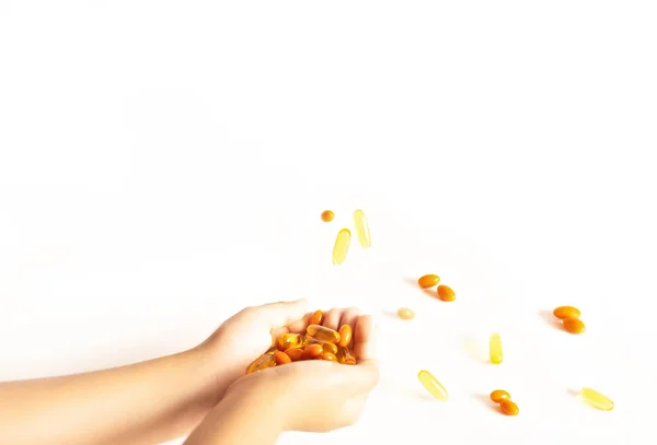 Yukarıdan düşen Omega 3 vitaminlerini yakalayan bir adamın elleri..