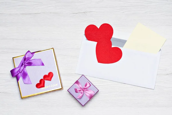 Sevgililer gününde yazmak için beyaz bir kağıt parçası ve hediye kutusu olan bir zarf..