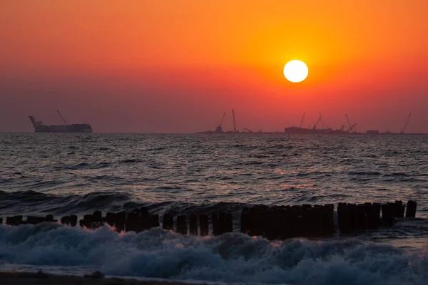 Büyük dalgalar ve yelkenli teknelerle deniz batımı.