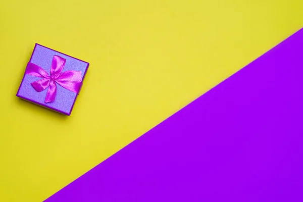 Sarı arka planda bir hediye ve tebrik etmek için bir yer..