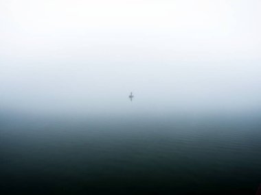 Gölün ortasındaki teknesinde yalnız bir balıkçı.