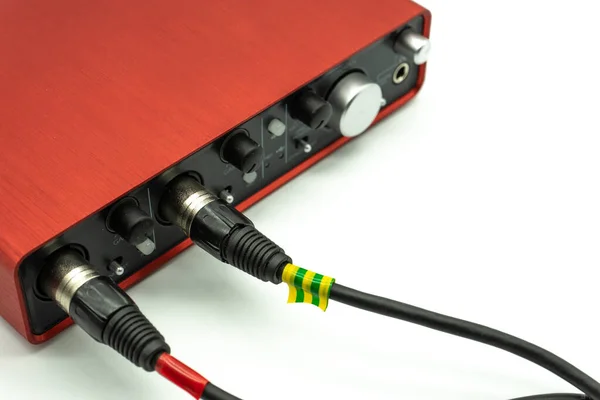 Panel frontal de interfaz de audio USB con controles de volumen y mezcla de canales, tarjeta de sonido externa de color rojo sobre fondo blanco de cerca Fotos de stock libres de derechos