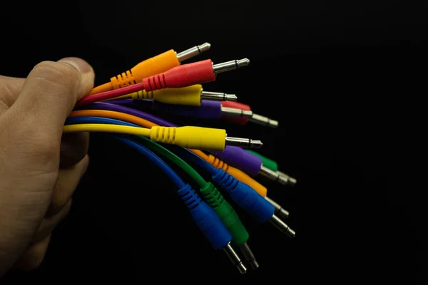 Рука держит цветные кабели разъема на изолированном черном фоне, выбранный фокус, копировать пасту, технологическая концепция — стоковое фото