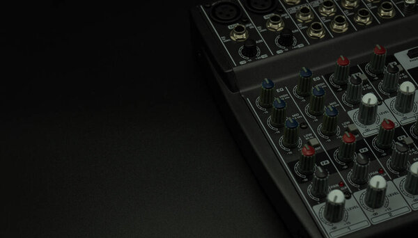 Close up professional sound and audio mixer control panel with buttons and sliders, audio inputs and outputs isolated on a black background, copy-paste, concept music