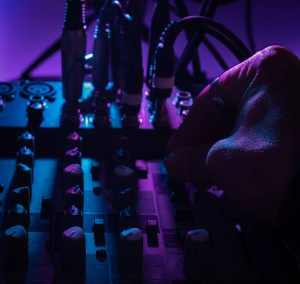 Vista de cerca del escritorio de mezcla de audio en el estudio de música con una mano en movimiento perillas, concepto de música —  Fotos de Stock