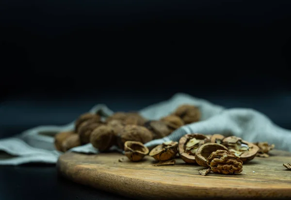 Kapalı fındıklı, fındıklı, fındıklı, fındıklı, sağlıklı besin konsepti olan tahta bir tahtanın üzerindeki açık cevizi yakından görmek.