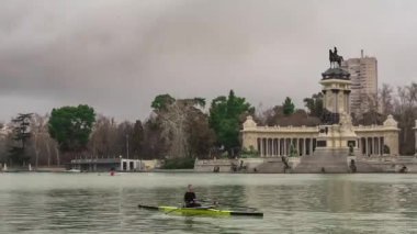 Madrid 'deki El Retiro Parkı, gölün diğer tarafındaki Alfonso Xii heykelinin manzarası, bulutlu bir günde. Seyahat kavramı.