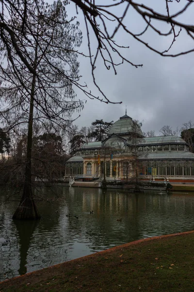 Madrid 'deki Retiro Park' taki lagün ve Kristal Saray manzarası. Dikey görünüm, gündoğumu kavramı.