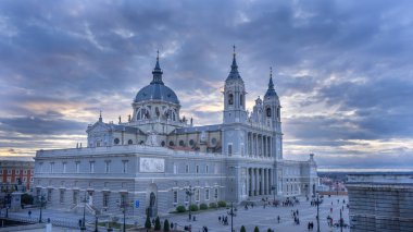 Madrid, İspanya 'daki Almudena Katedrali' nde bulutlu bir günde, meydandaki insanlarla mavi saat. 29 Şubat 2020. Seyahat kavramı.