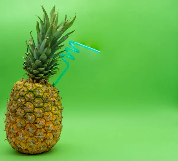 Solda yeşil arka planda mavi kıvrımlı samanlı ananas ve sağda yazı için boşluk. Sağlıklı gıda konsepti.