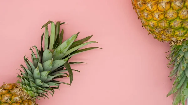 Vista superior de dois abacaxis que se encontram isolados em um fundo rosa. Conceito de fruta tropical . — Fotografia de Stock