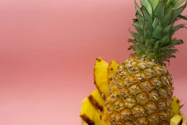 Közelkép a szeletelt ananász, elszigetelt rózsaszín háttér, a szöveg a bal oldalon. Vízszintes látásmód. Egészséges és ökológiai élelmiszer-koncepció. — Stock Fotó