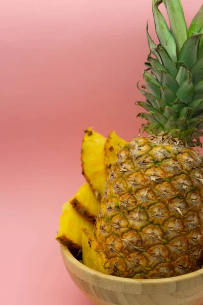 Vista de perto de abacaxi fatiado, isolado em um fundo rosa, com espaço para texto à esquerda. Imagem vertical. Conceito alimentar saudável e ecológico . — Fotografia de Stock