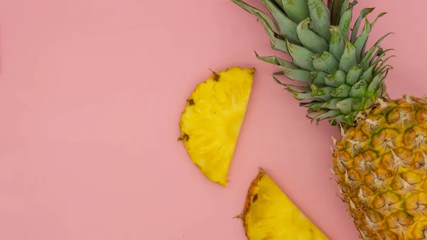 Vista zenital de abacaxi inteiro com fatias em torno dele, isolado em um fundo rosa. Conceito alimentar saudável e ecológico . — Fotografia de Stock
