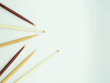 Top view of drumsticks on the left of the image on a white background , with space to the right of the image for text Concept of musical instruments.