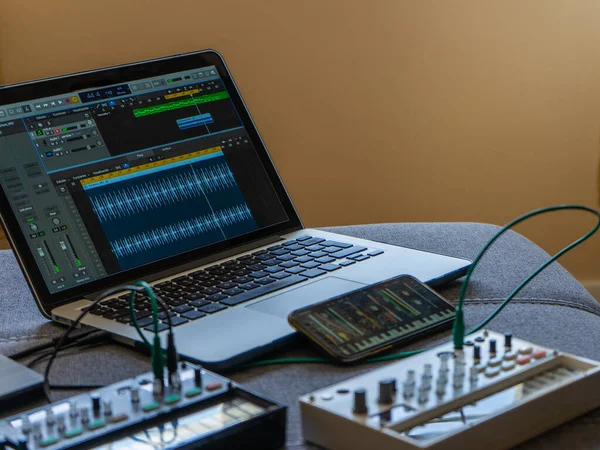 FM synthesizer, numune, modüler sentezleyicili akıllı telefon ve Daw 'lı dizüstü bilgisayar görüntülerini kapat. Elektronik müzik konsepti.