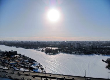 Kışın soğuk ve güneşli bir günde Leningradsky Otoyolu 'nda panoramik hava manzarası. Güzel şehir peyzajı nehri buzla kaplı. Arabalar köprüde. İHA atışı..