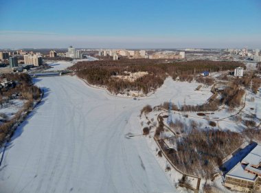 Kışın soğuk ve güneşli bir günde Leningradsky Otoyolu 'nda panoramik hava manzarası. Güzel şehir peyzajı nehri buzla kaplı. Arabalar köprüde. İHA atışı..