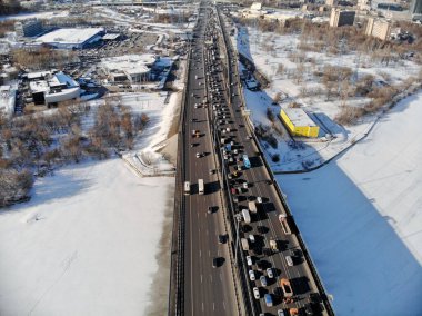 Kışın soğuk ve güneşli bir günde Leningradsky Otoyolu 'nda panoramik hava manzarası. Güzel şehir peyzajı nehri buzla kaplı. Arabalar köprüde. İHA atışı..