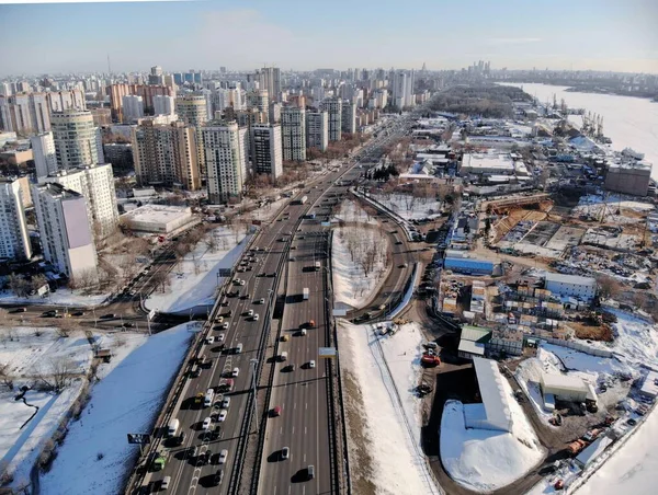 Панорамний вигляд на Ленінградське шосе в холодний сонячний день взимку. Чудова міська ландшафтна річка вкрита льодом. Машини на бридж. Дронові постріли.. — стокове фото