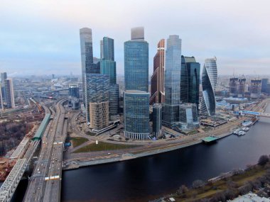 Aerial view of modern high-rise buildings of the business center Moscow City on the river embankment. Beautiful panorama of the city center in autumn with a drone.