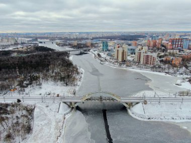 Aerial view beautiful urban landscape railway bridge over freezing river from drone